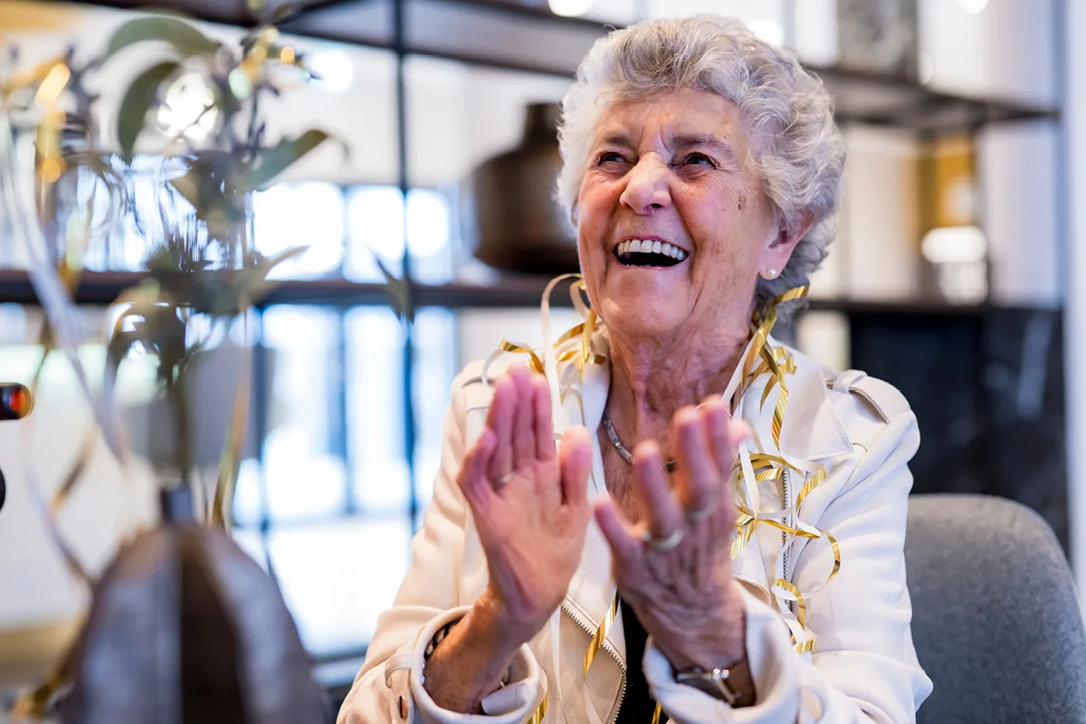Lachende Dame mit Girlande SCHÖNES LEBEN Exklusives Service-Wohnen