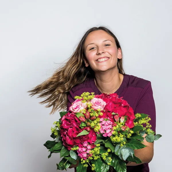 SCHÖNES LEBEN Pflegefachkraft Pflegehilfskraft mit Blumenstrauss